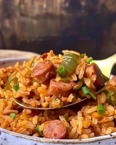 Plato de arroz con salchicha servido en un tazón, ideal para una comida casera.