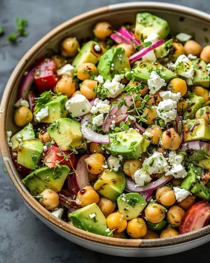 Ensalada de garbanzos con feta y aguacate en un plato colorido