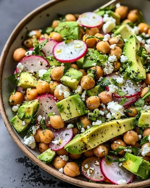 Ensalada de garbanzos con feta y aguacate en un plato colorido