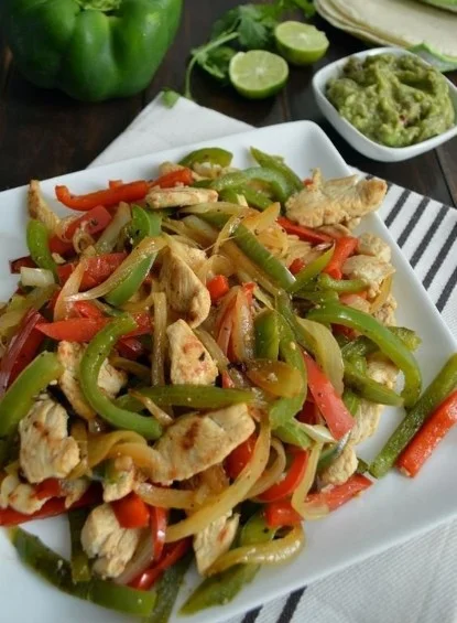 Fajitas de pollo servidas con verduras frescas y tortillas calientes