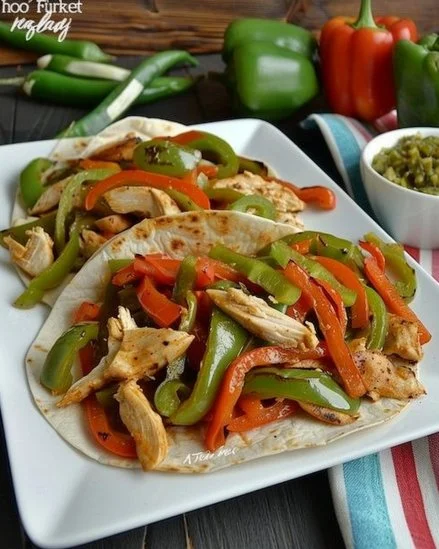 Fajitas de pollo acompañadas de verduras y salsas