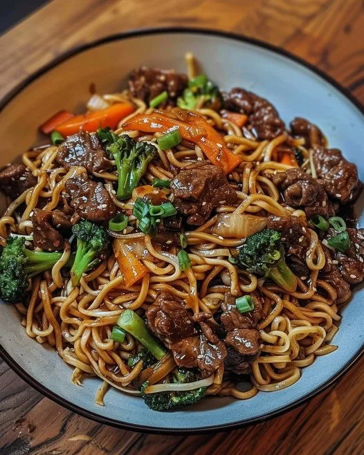 Fideos salteados con carne de res y salsa pegajosa en plato colorido