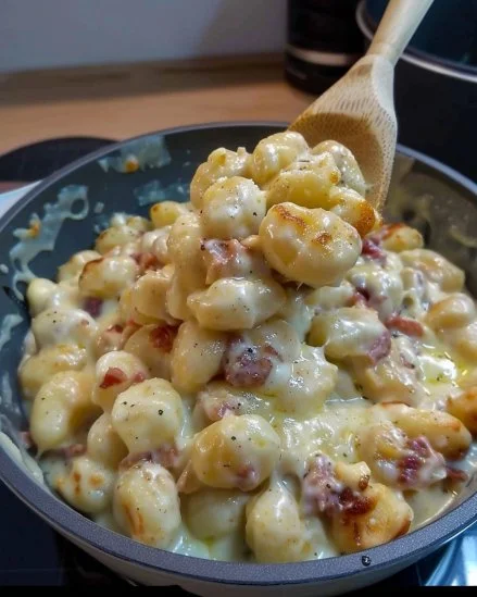 Plato de gnocchis de queso con salsa y queso rallado
