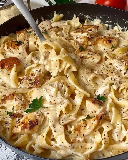 Pasta de Pollo con Ajo y Parmesano servida en un plato blanco.