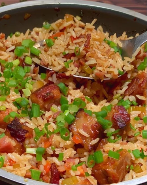 Plato de Arroz con Panceta servido en un tazón, decorado con hierbas frescas.