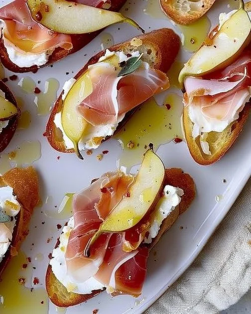 Crostini de pera y prosciutto dulce y salado en un plato decorativo