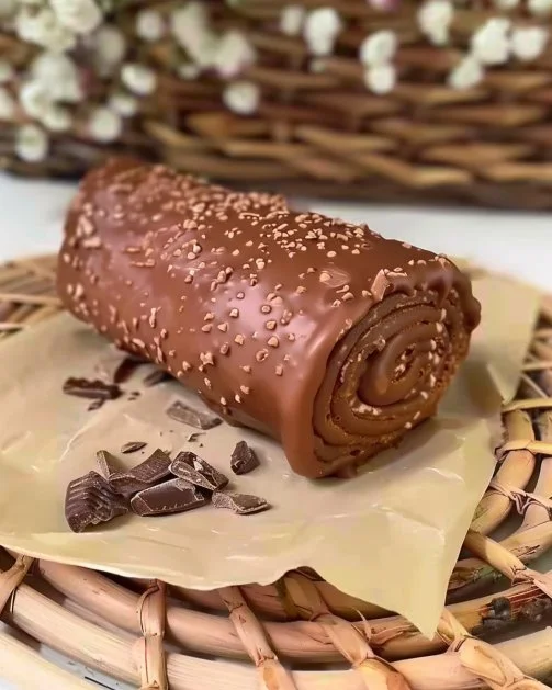 Rollito de crepas de chocolate servido con salsa de chocolate y frutas