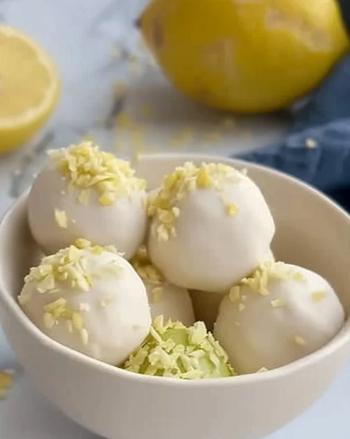 Bolitas de pie de limón decoradas con crema y ralladura de limón