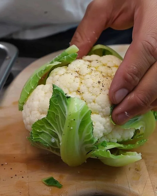Plato de coliflor parmesana recién horneada con queso y especias