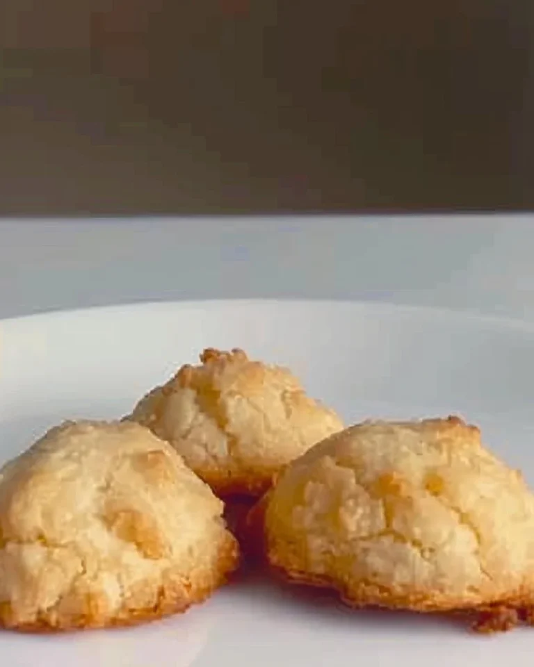 Galletitas de coco recién horneadas sobre una mesa de madera.