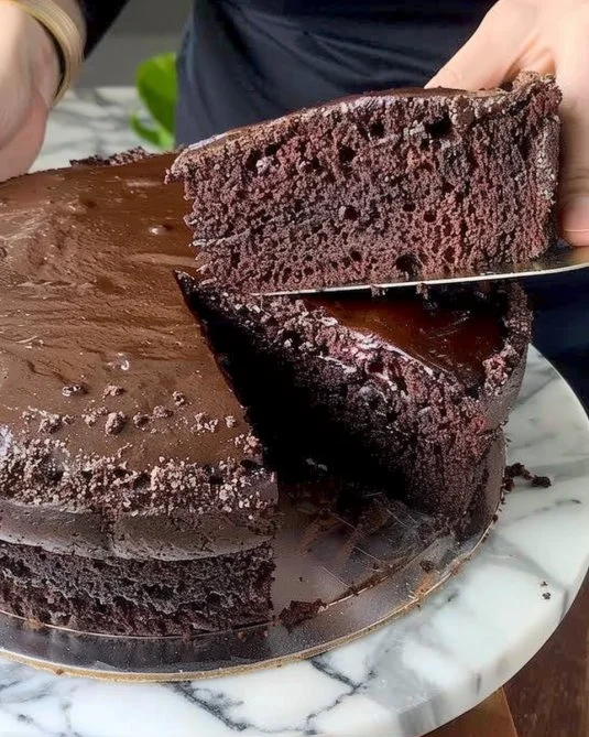 Tarta de chocolate decorada con fresas y crema en un plato.