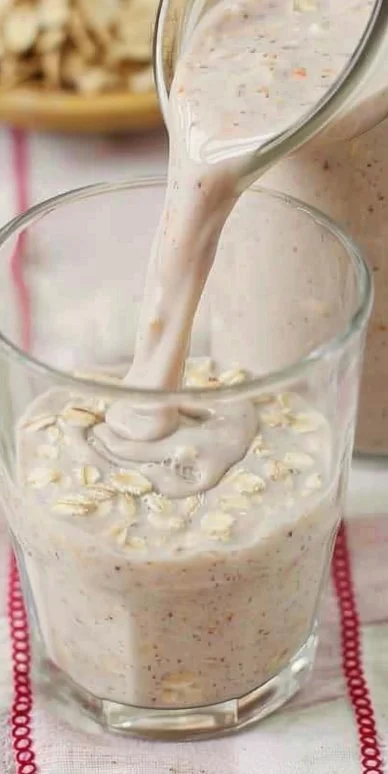 Avena fría colombiana servida en un vaso con frutas y canela.