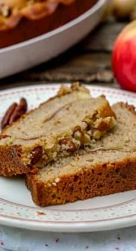 Bizcocho de manzana, nueces y canela recién horneado en un plato.