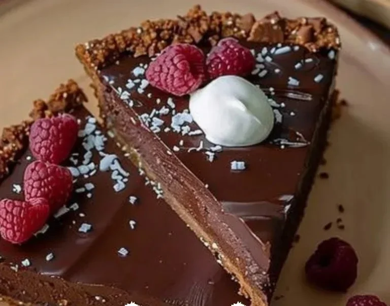 Tarta de chocolate decadente decorada con virutas de chocolate y fresas.